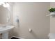 Modern powder room with a pedestal sink, stylish mirror, and minimalist design at 4014 White Kestrel Dr, Raleigh, NC 27616