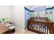 Bedroom features ocean-themed decor, a wooden crib, and a comfortable rocking chair at 4014 White Kestrel Dr, Raleigh, NC 27616