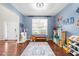 Comfortable playroom with wood floors, blue accent wall, and lots of natural light at 4014 White Kestrel Dr, Raleigh, NC 27616