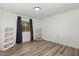Bright bedroom with wood-look floors, curtained windows, and a wall-mounted shelf at 5840 Fayetteville Rd, Raleigh, NC 27603