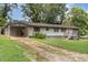 Charming single-story home with a well-maintained lawn, gravel driveway, and covered carport at 5840 Fayetteville Rd, Raleigh, NC 27603
