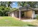 Property showing a parking shed and home surrounded by a well-maintained lawn and mature trees at 5840 Fayetteville Rd, Raleigh, NC 27603