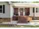 Inviting brick front porch with a red front door and brick steps at 5840 Fayetteville Rd, Raleigh, NC 27603