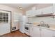 Functional kitchen with white cabinets, gas range, compact refrigerator, and wood-look vinyl flooring at 5840 Fayetteville Rd, Raleigh, NC 27603