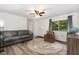 Comfortable living room with a couch, armchair, ceiling fan and wood-look flooring at 5840 Fayetteville Rd, Raleigh, NC 27603
