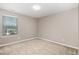 This bedroom has neutral walls, plush carpet, and a large window offering views of the outside at 812 Teal Lake Dr, Holly Springs, NC 27540