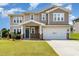 Two-story home featuring a blue front door and an attached two-car garage with verdant lawn at 812 Teal Lake Dr, Holly Springs, NC 27540