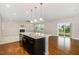 The open concept kitchen features granite countertops, stainless steel appliances, and a kitchen island at 812 Teal Lake Dr, Holly Springs, NC 27540