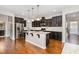 A modern kitchen with stainless steel appliances, a large island, and dark cabinetry at 812 Teal Lake Dr, Holly Springs, NC 27540