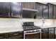 This kitchen has stainless steel oven and cooktop with dark cabinetry and granite countertops at 812 Teal Lake Dr, Holly Springs, NC 27540