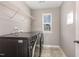 Modern laundry room with washer, dryer, shelving, and natural light, offering convenience at 812 Teal Lake Dr, Holly Springs, NC 27540