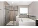 Stylish bathroom showcasing a glass shower and soaking tub with tiled surround, providing a modern and luxurious feel at 812 Teal Lake Dr, Holly Springs, NC 27540