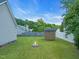 Green backyard with a fire pit, storage shed, and privacy fence at 104 Roscommon Ln, Clayton, NC 27520