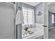 Bright bathroom featuring a white bathtub with tub caddy, a shower with glass doors, and a floral window curtain at 104 Roscommon Ln, Clayton, NC 27520