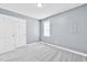 Neutral bedroom featuring gray carpet, a double door closet and a bright window at 104 Roscommon Ln, Clayton, NC 27520