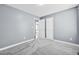 Well-lit bedroom with neutral walls, plush gray carpet, and two white doors at 104 Roscommon Ln, Clayton, NC 27520