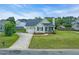 Exterior view of a charming one-story home with a well-maintained lawn and long driveway at 104 Roscommon Ln, Clayton, NC 27520