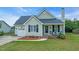Charming single Gathering home features a well-manicured lawn, tidy landscaping, and a cozy front porch at 104 Roscommon Ln, Clayton, NC 27520