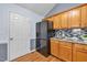 Well-appointed kitchen with wooden cabinets, granite countertops, and a modern black refrigerator at 104 Roscommon Ln, Clayton, NC 27520