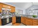 Kitchen with wooden cabinetry, granite countertops, stainless steel sink, and modern appliances at 104 Roscommon Ln, Clayton, NC 27520