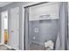 A functional laundry area with gray walls, white wire shelves, and gray curtain at 104 Roscommon Ln, Clayton, NC 27520
