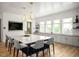 Elegant kitchen featuring a large island with seating, modern lighting and cabinetry at 194 Aspen Ave, Pittsboro, NC 27312