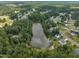 Aerial view of community and surrounding treeline and pond at 2003 Zbonack Ct, Creedmoor, NC 27522