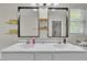 Bathroom featuring double sinks, a white cabinet, large mirrors, and floating wood shelves at 2003 Zbonack Ct, Creedmoor, NC 27522