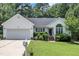 Home featuring a manicured lawn, attached garage, and well-maintained landscaping at 2003 Zbonack Ct, Creedmoor, NC 27522
