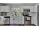 A pristine kitchen boasts white cabinets, modern stainless steel appliances, and a large window over the sink at 2003 Zbonack Ct, Creedmoor, NC 27522