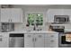 Bright kitchen featuring white cabinets, quartz countertops, stainless steel appliances, and a sunlit window at 2003 Zbonack Ct, Creedmoor, NC 27522