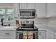 Bright kitchen featuring white cabinets, quartz countertops, and stainless steel appliances at 2003 Zbonack Ct, Creedmoor, NC 27522