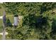 Aerial view of the property showing home, detached garage and surrounding green, wooded acreage at 3603 Grimes Ave, Durham, NC 27703