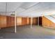 Unfinished basement featuring wood paneling, support beams, and carpet flooring at 3603 Grimes Ave, Durham, NC 27703