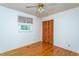 Bright bedroom with hardwood floors, ceiling fan, and a window overlooking the backyard at 3603 Grimes Ave, Durham, NC 27703