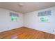 Bedroom boasting bright hardwood floors and two windows dressed with blue patterned valances at 3603 Grimes Ave, Durham, NC 27703