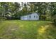 A detached, two-bay garage sits on a grassy lot, surrounded by trees providing shade and privacy at 3603 Grimes Ave, Durham, NC 27703