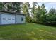 Side angle of detached, two-bay garage and well-maintained grassy lot, surrounded by trees at 3603 Grimes Ave, Durham, NC 27703