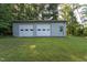Outbuilding with two garage doors and an entrance door on a large lawn at 3603 Grimes Ave, Durham, NC 27703