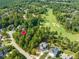 Beautiful aerial view of property on golf course with mature trees, golf course with sand traps, and manicured lawn at 104 Birdie Court, Pittsboro, NC 27312