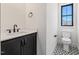 Powder room features a black vanity with a white countertop and patterned tile floor at 104 Birdie Court, Pittsboro, NC 27312