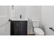 Modern powder room featuring white walls, a black vanity, and a toilet at 104 Birdie Court, Pittsboro, NC 27312