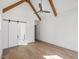 Bedroom with vaulted ceilings and exposed beams with barn door entrance to bathroom at 104 Birdie Court, Pittsboro, NC 27312