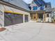 Side view of three car garage with a concrete driveway and wooden details at 104 Birdie Court, Pittsboro, NC 27312