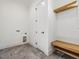 Mudroom featuring gray tile floors, a white door, and built-in wooden bench with overhead shelf at 104 Birdie Court, Pittsboro, NC 27312