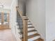 Staircase featuring hardwood treads, white risers, and dark metal spindles with a wood handrail at 104 Birdie Court, Pittsboro, NC 27312