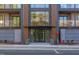 Close-up of the building's entrance, with glass doors, concrete sidewalk and landscaped grounds at 600 N Roxboro St # 21, Durham, NC 27701
