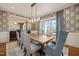 Formal dining room with large table, patterned wallpaper, and hardwood floors at 291 Riverstone Dr, Pittsboro, NC 27312