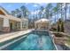 Resort-style pool and outdoor kitchen with stone accents at 291 Riverstone Dr, Pittsboro, NC 27312