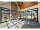 Sunroom features stone flooring, fireplace, and wall of windows at 291 Riverstone Dr, Pittsboro, NC 27312